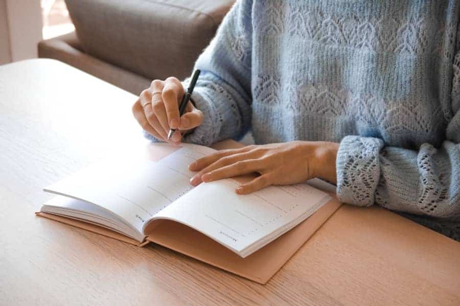 woman prioritizing tasks in planner