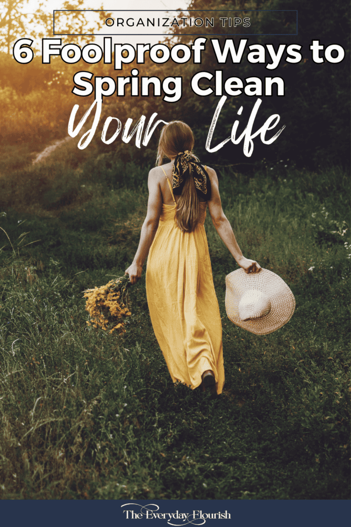 A woman in a flowy yellow dress walking through a forest with a bouquet of yellow flowers in one hand and a hat in the other, embodying the transformative journey to spring clean your life.