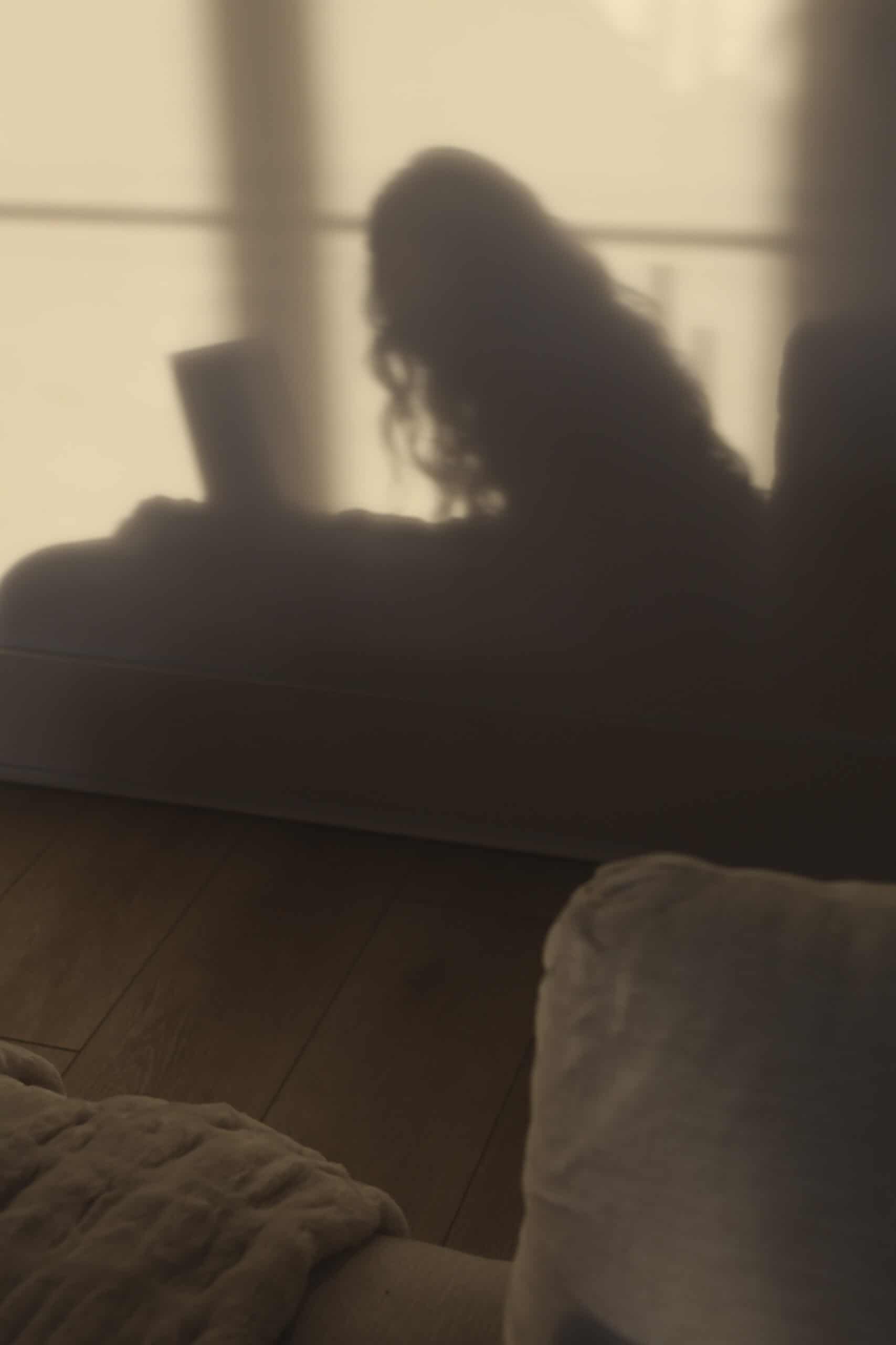 Shadow of a woman leaning toward a laptop screen, symbolizing how an ADHD brain won't shut off.